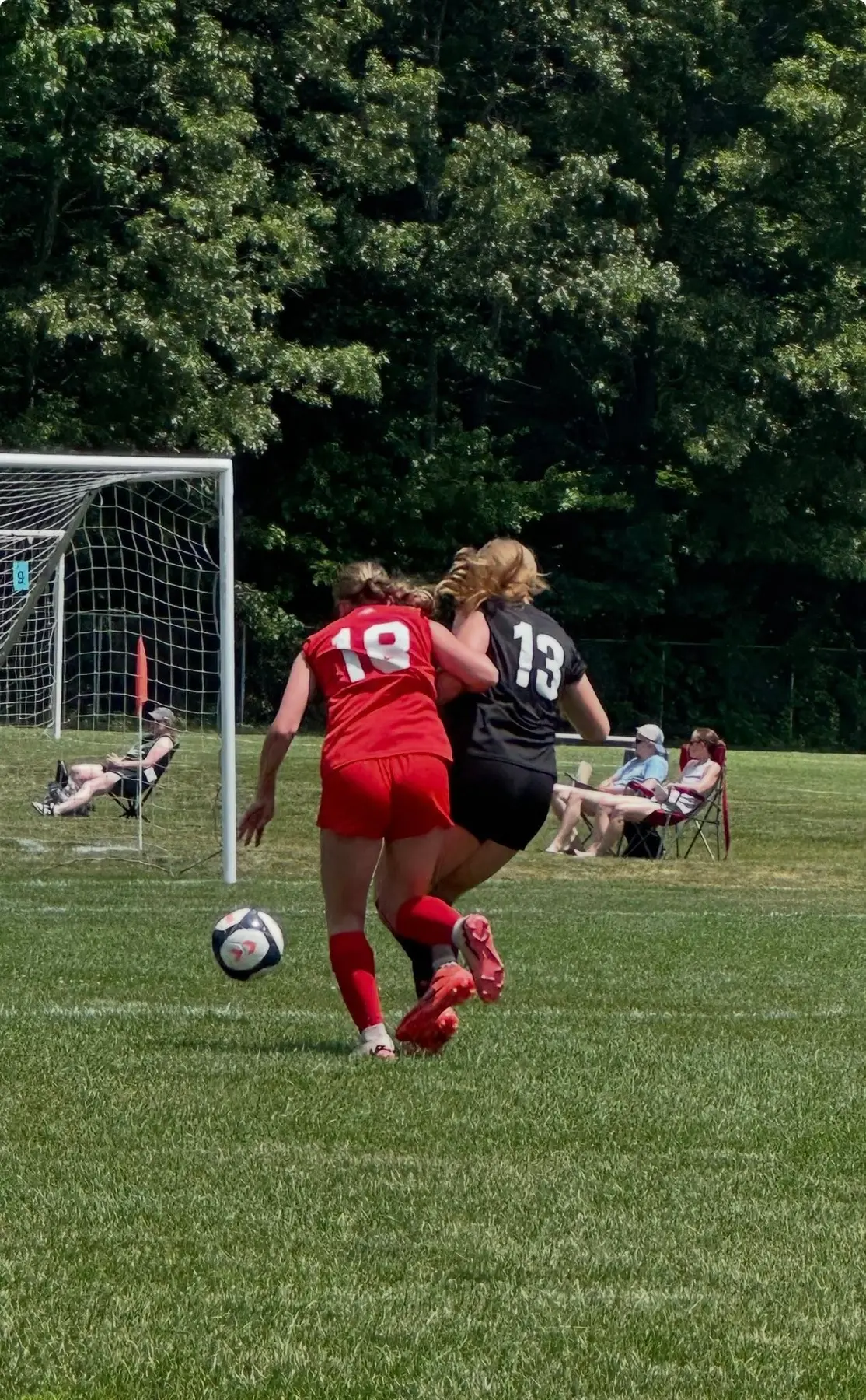 Izabel Barmosz wearing number 13 competing shoulder-to-shoulder for the ball